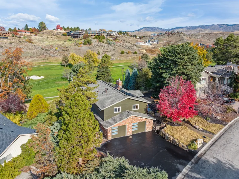 Aerial view of a Boise Foothills home with golf course views, vibrant trees, and a spacious lot, captured with professional drone photography.