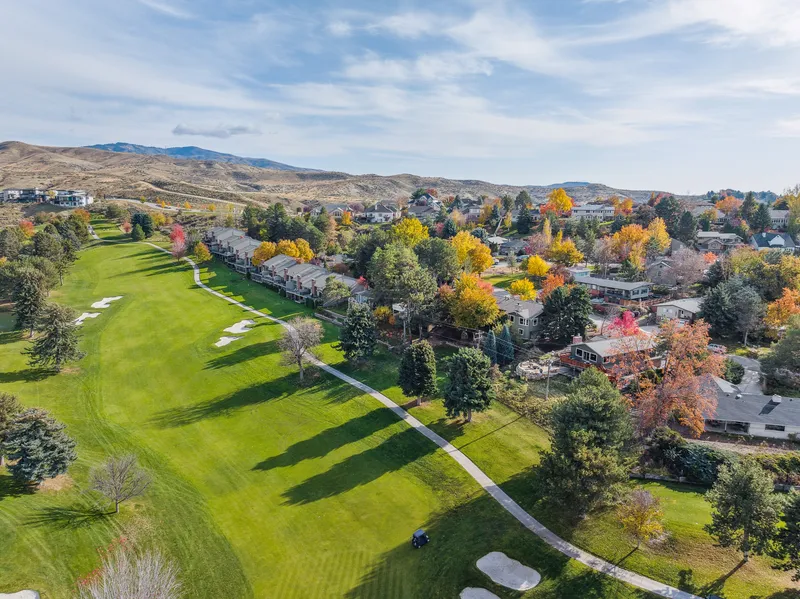 Aerial view of a Boise, Idaho golf course community with mature trees, fall foliage, and scenic foothills captured with professional drone photography.