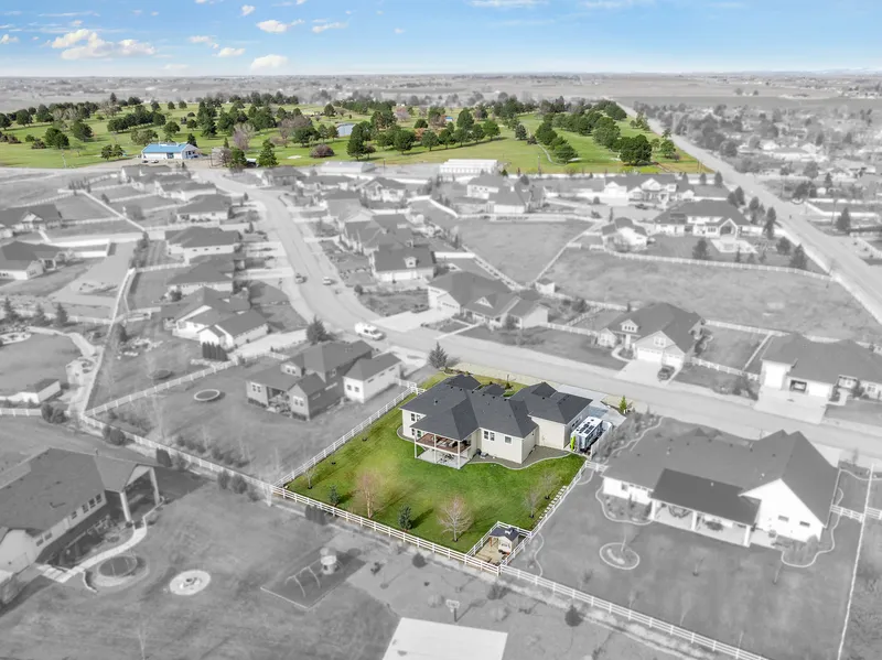 Aerial view of a home in Caldwell, Idaho, with a highlighted golf course in the background, showcasing the property's proximity to recreational amenities.