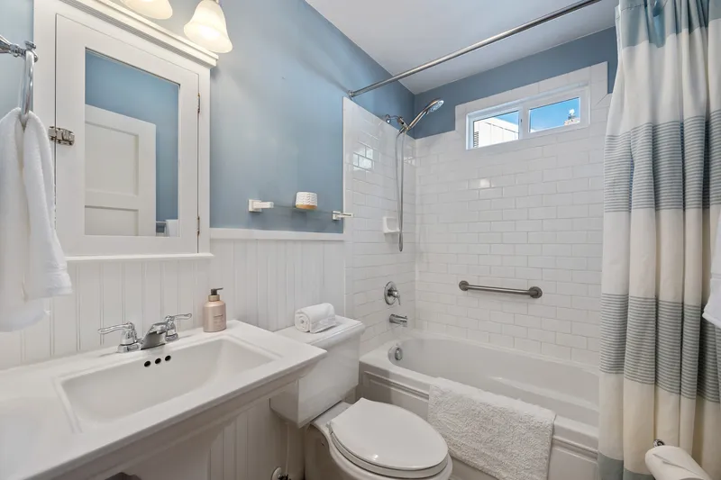 Charming guest bathroom in Caldwell, Idaho, with beadboard paneling, white subway tiles, and soft blue walls, ideal for real estate listings and rental properties.