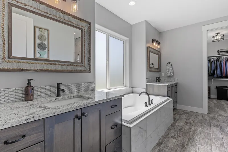 Elegant master bathroom in Eagle with dual vanities, a soaking tub, and a spacious walk-in closet, highlighted in a professional real estate photography session.