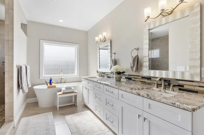 Luxury master bathroom with a freestanding tub, dual vanity, granite countertops, and a walk-in shower in a modern Treasure Valley home.