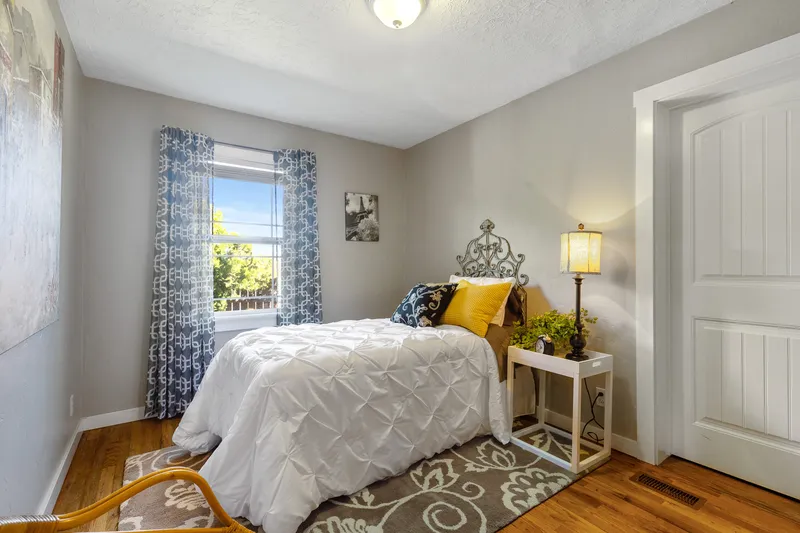 Cozy bedroom in Boise home with natural light, elegant decor, and warm hardwood floors, ideal for real estate listings and home staging photography.