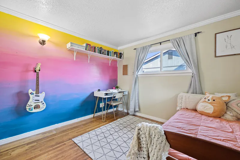Boise bedroom with a vibrant accent wall, workspace, and cozy bed, ideal for real estate listings and home decor inspiration.