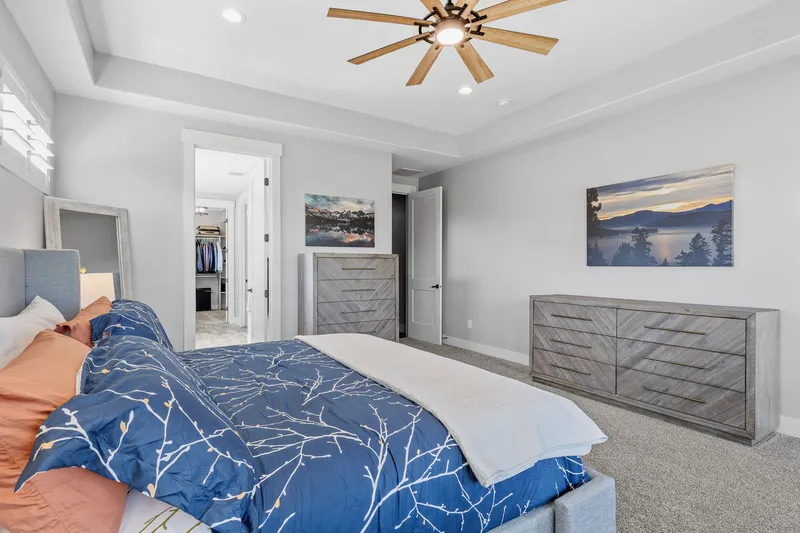 Elegant master bedroom in Eagle with plush carpet, tray ceiling, modern furniture, and a walk-in closet, highlighted in a luxury real estate photography session.