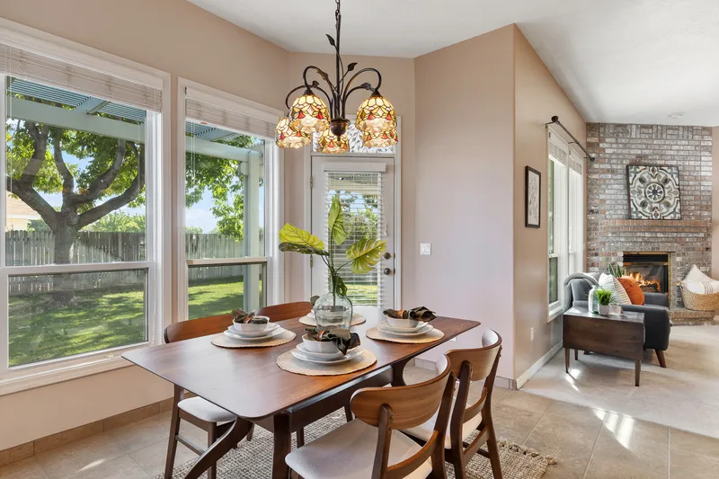 Bright open-concept living and dining space in Garden City, Idaho, with modern kitchen, wood dining table, and natural lighting, professionally photographed for real estate marketing.