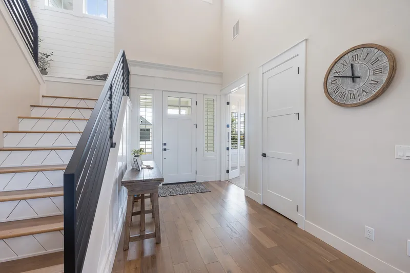 Modern farmhouse entryway in Garden City, Idaho, with tall ceilings, shiplap accents, and a staircase, professionally photographed for real estate listings.