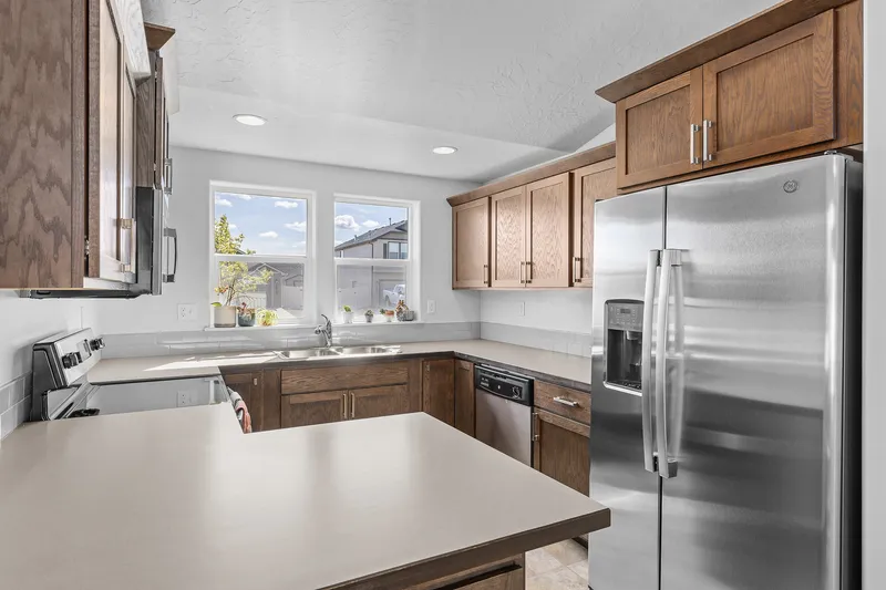 Modern kitchen in Garden City, Idaho, with wood cabinetry, stainless steel appliances, and natural light, professionally photographed for real estate marketing.