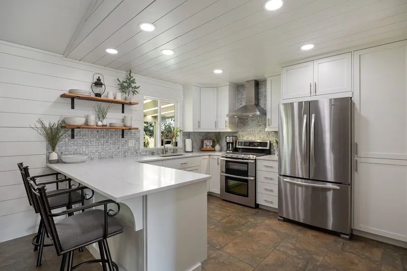Modern kitchen in Kuna, Idaho, with white cabinetry, quartz countertops, and shiplap walls, professionally photographed for real estate listings and rental marketing.